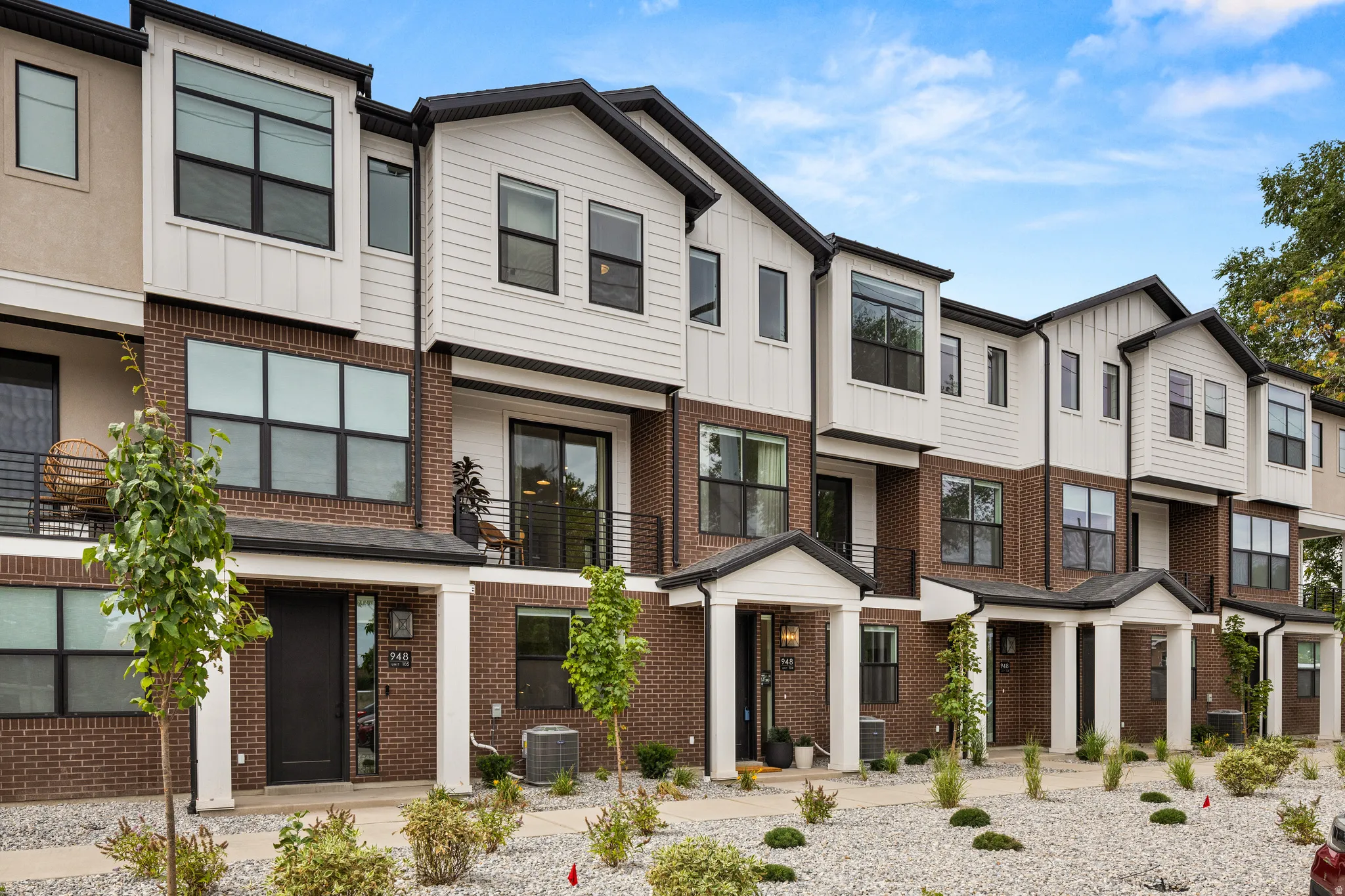 Modern townhome exteriors featuring brick and white siding