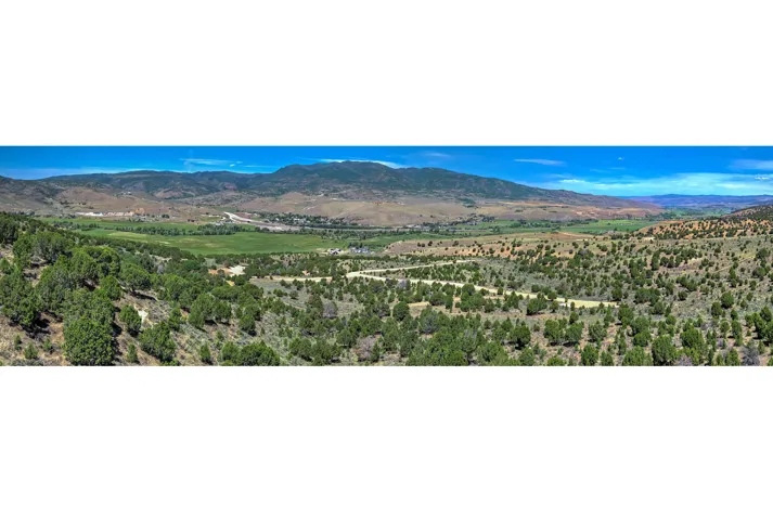 Expansive panoramic landscape featuring rolling hills and distant mountains