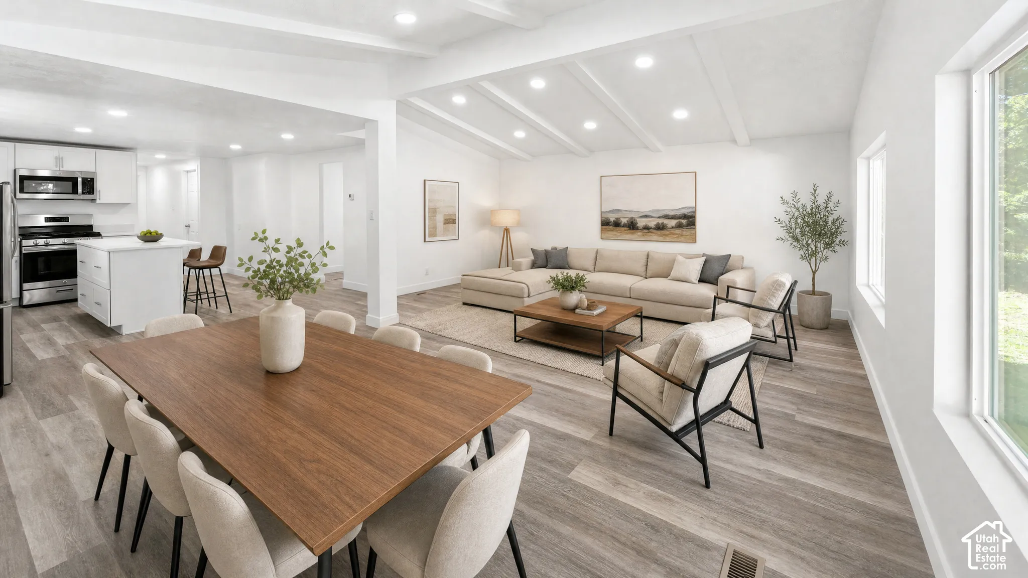 Bright interior featuring wood-finish flooring, recessed lighting, and a kitchen with stainless steel appliances