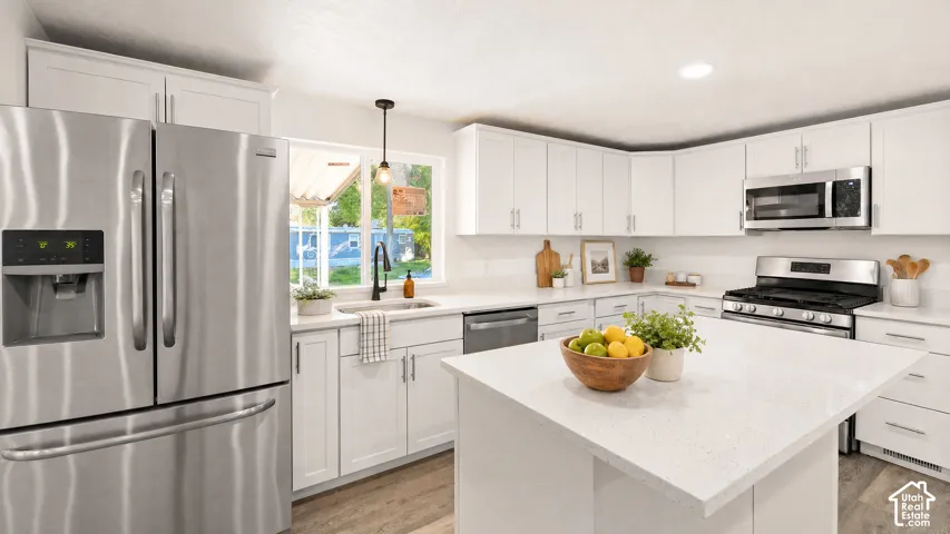 Modern kitchen featuring white shaker cabinetry, stainless steel appliances, light-toned countertops, a central island, and wood-finish flooring