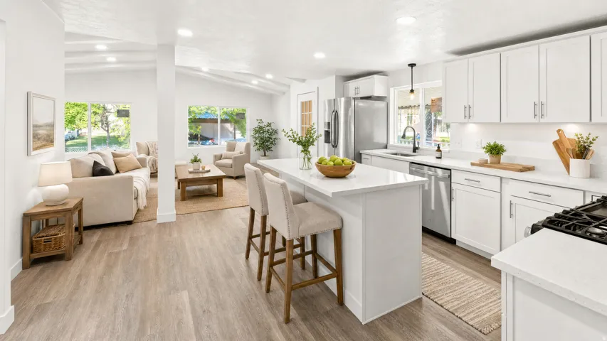Modern kitchen featuring white cabinetry, stainless steel appliances, a center island with bar seating, and light-colored countertops