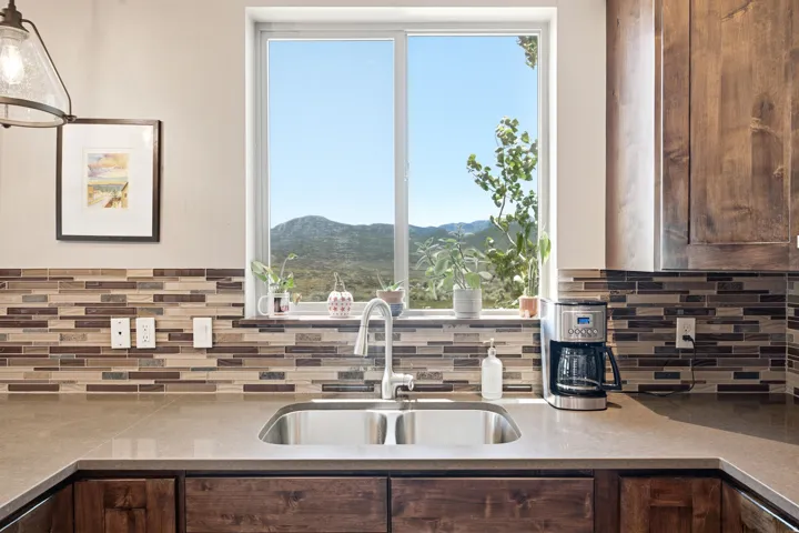 Double-basin stainless steel sink with a gooseneck faucet, set within a light-toned countertop
