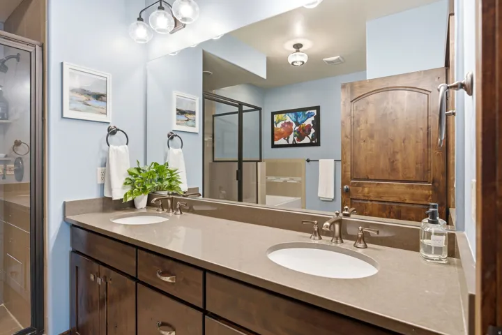 Spa-inspired primary bathroom featuring dual vanity with quartz countertop, undermount sink, and polished chrome fixtures