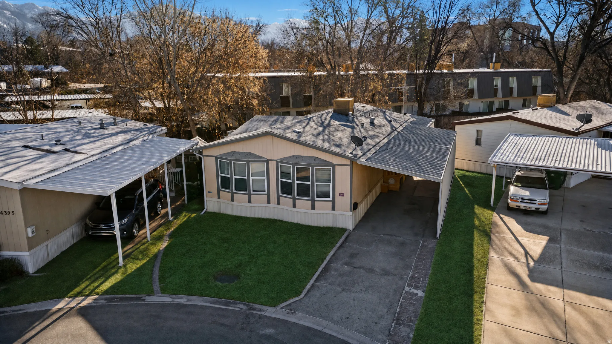 Single-story residence featuring a covered carport, bay windows with contrasting trim, and a shingle roof