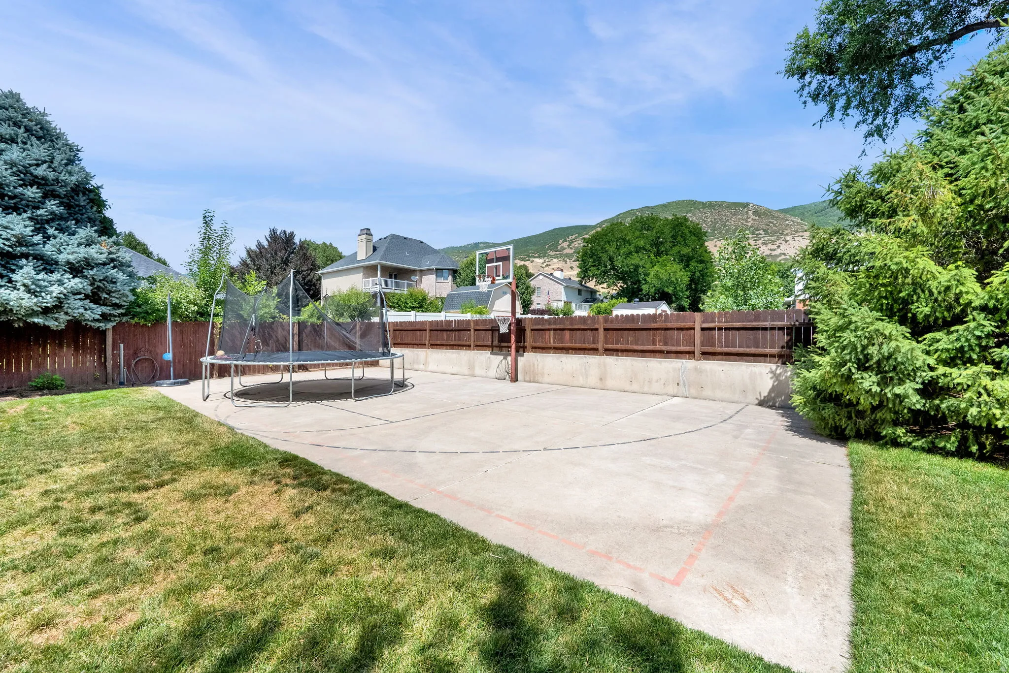 Concrete pickleball court with basketball hoop