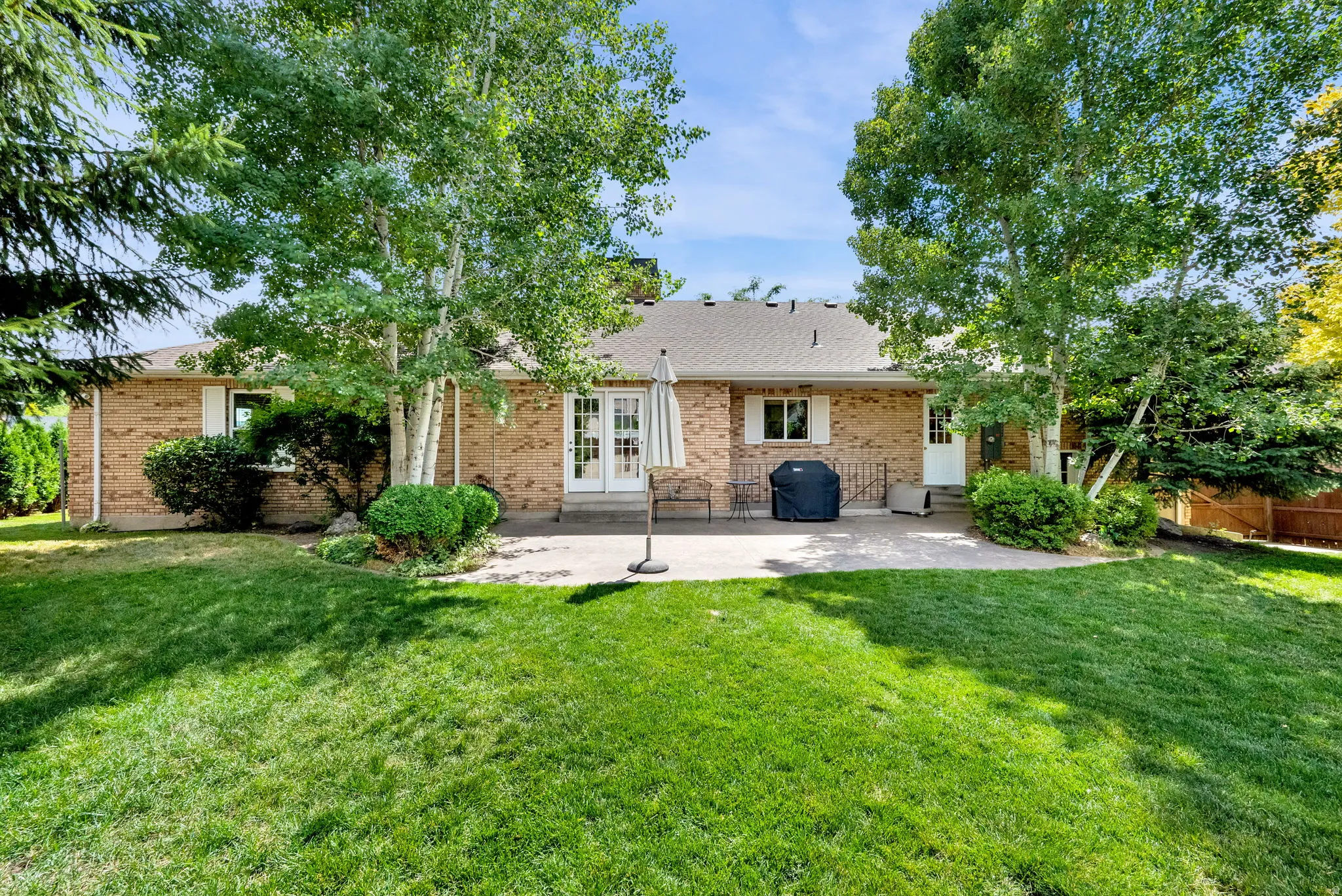 Expansive backyard featuring a large patio, and mature trees