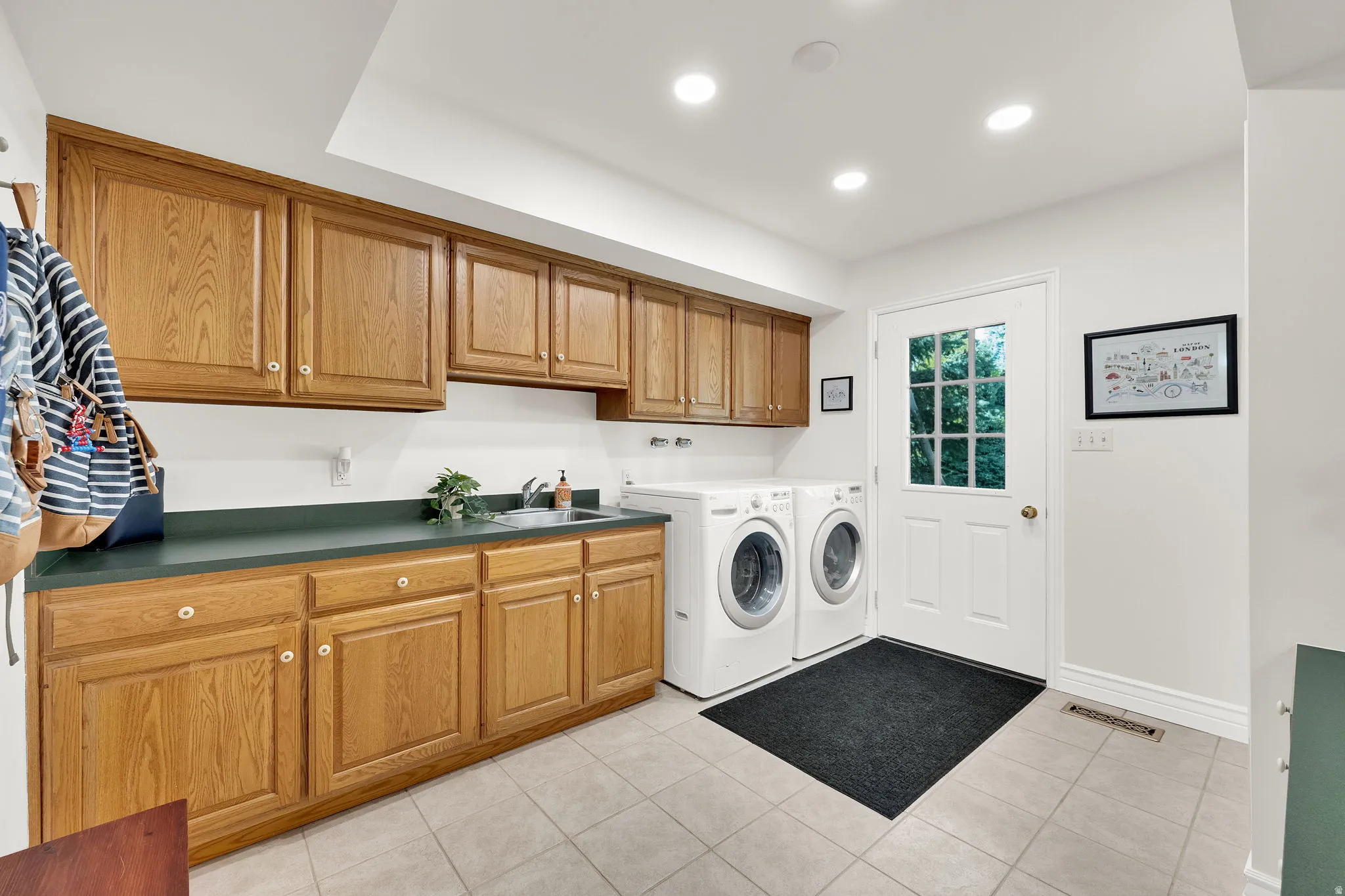 Huge laundry room with sink, cabinets walk door to backyard to double as a mud room