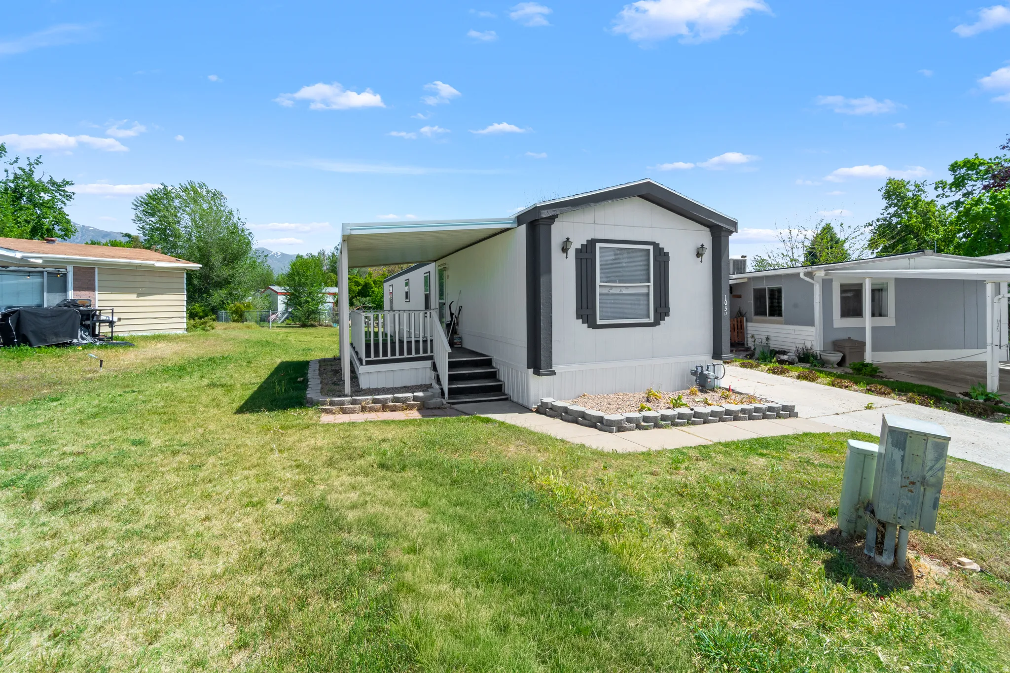 Manufactured home with an attached covered porch and white railing