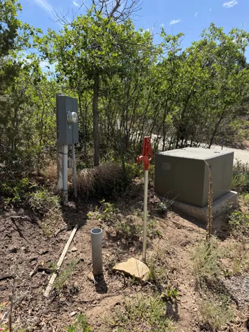 Utility connections present, including an electrical meter box and a water spigot