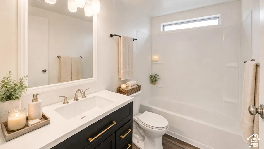 Contemporary bathroom featuring a dark vanity with gold-tone hardware, a white countertop with an integrated sink, and a framed mirror