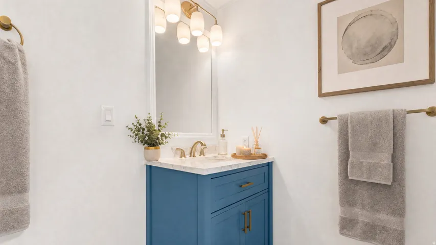 Bathroom vanity featuring a blue base cabinet with brass hardware, a white countertop, and a rectangular mirror