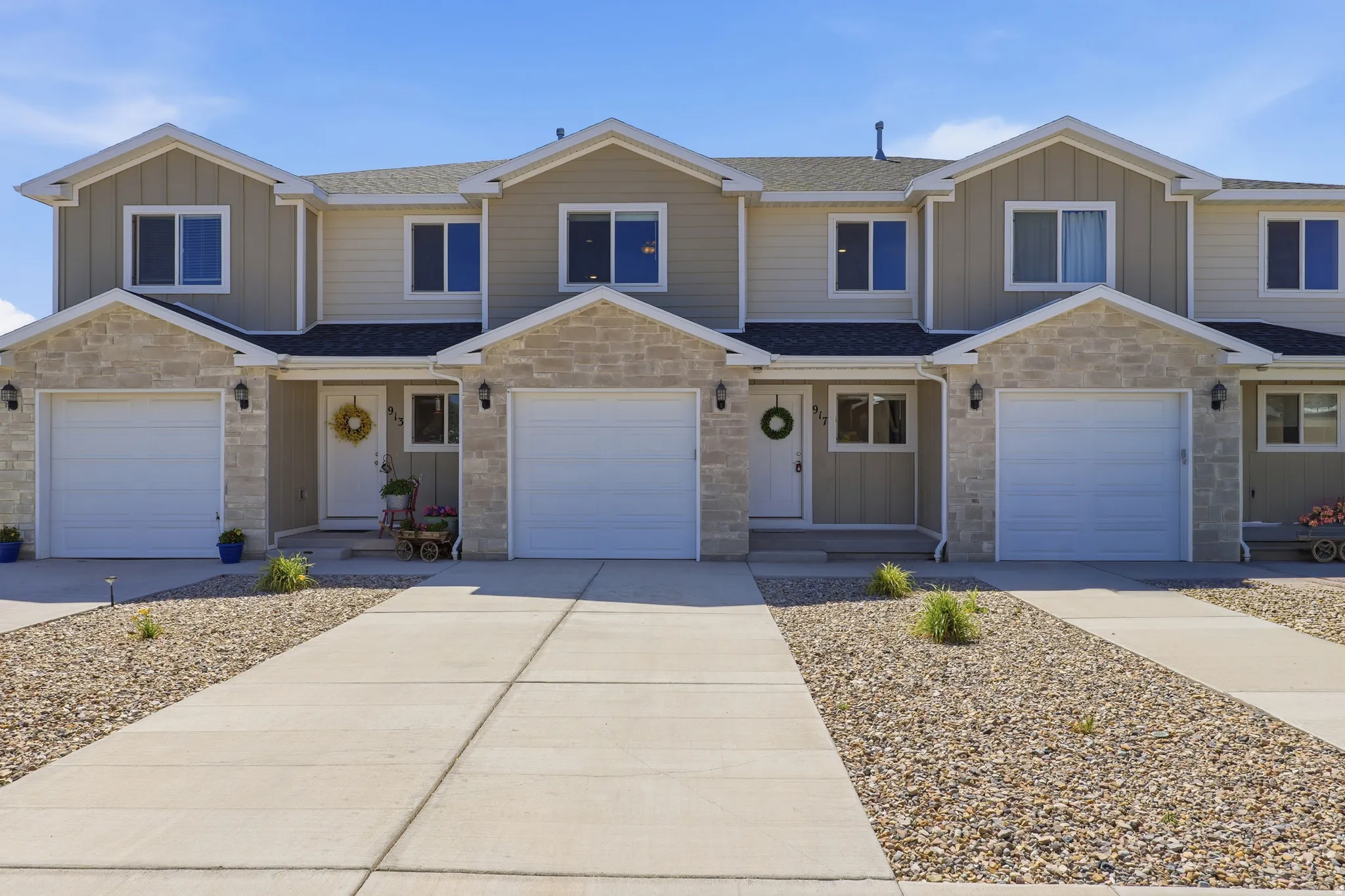 Contemporary townhome facade featuring a stone and siding exterior