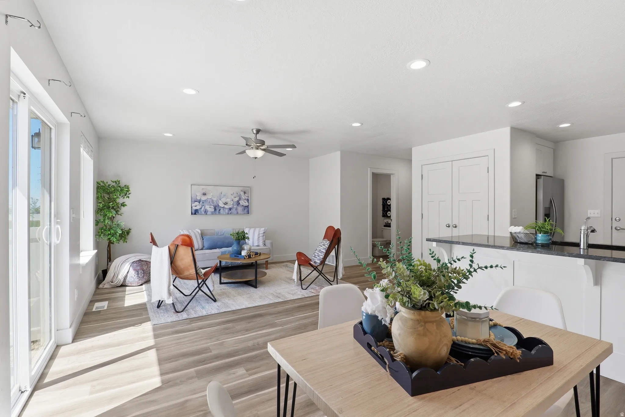 Open-concept living area featuring wood-finish flooring, recessed lighting, and a ceiling fan