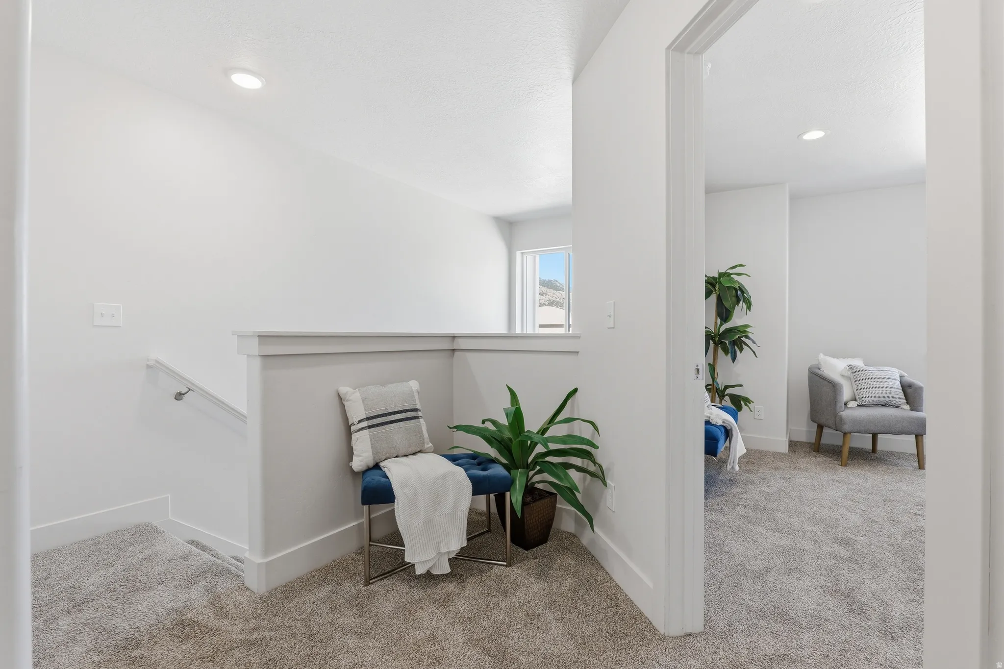 Upper-level landing featuring light gray carpeting and white walls