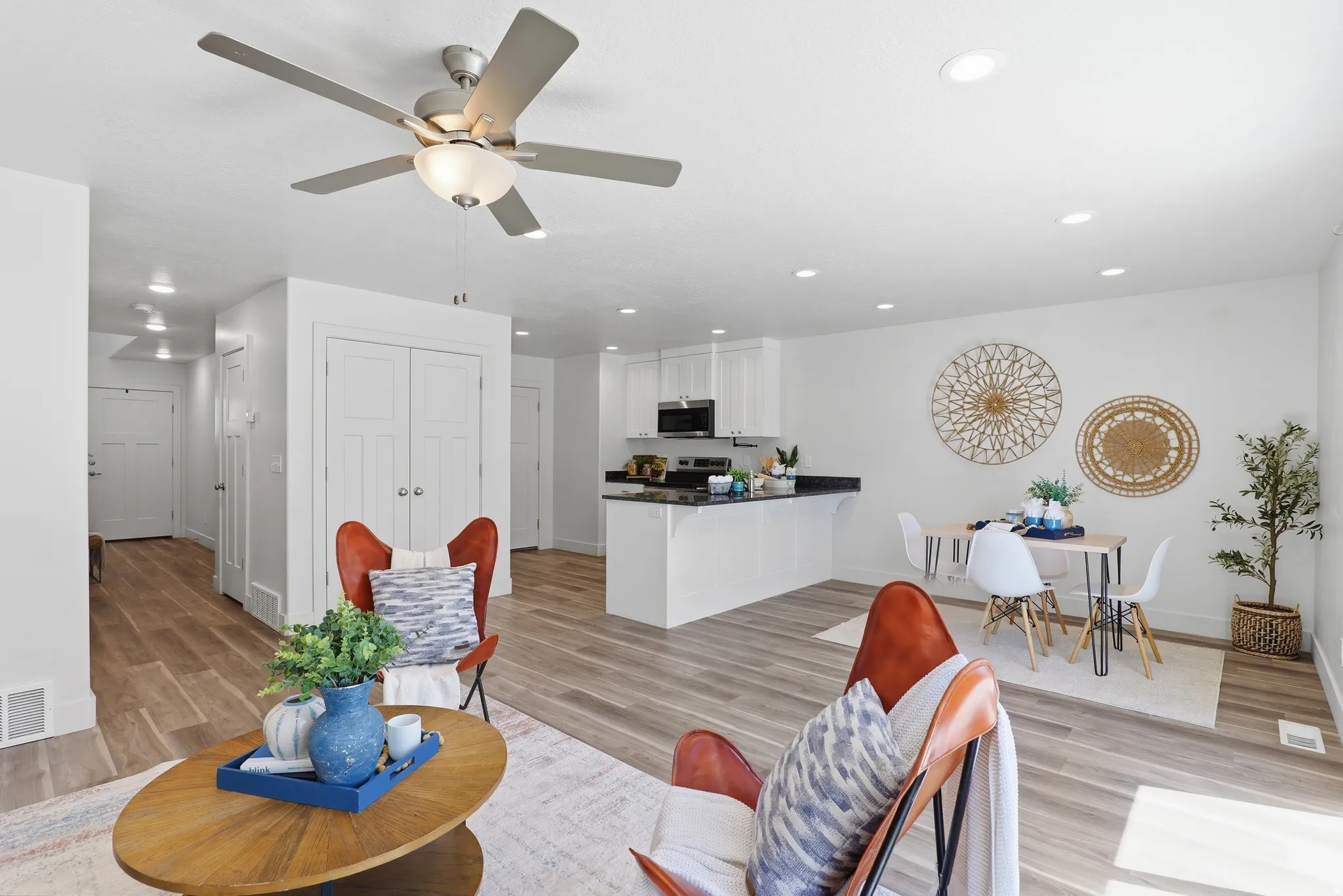Open-concept living area with wood-finish flooring, recessed lighting, and a ceiling fan