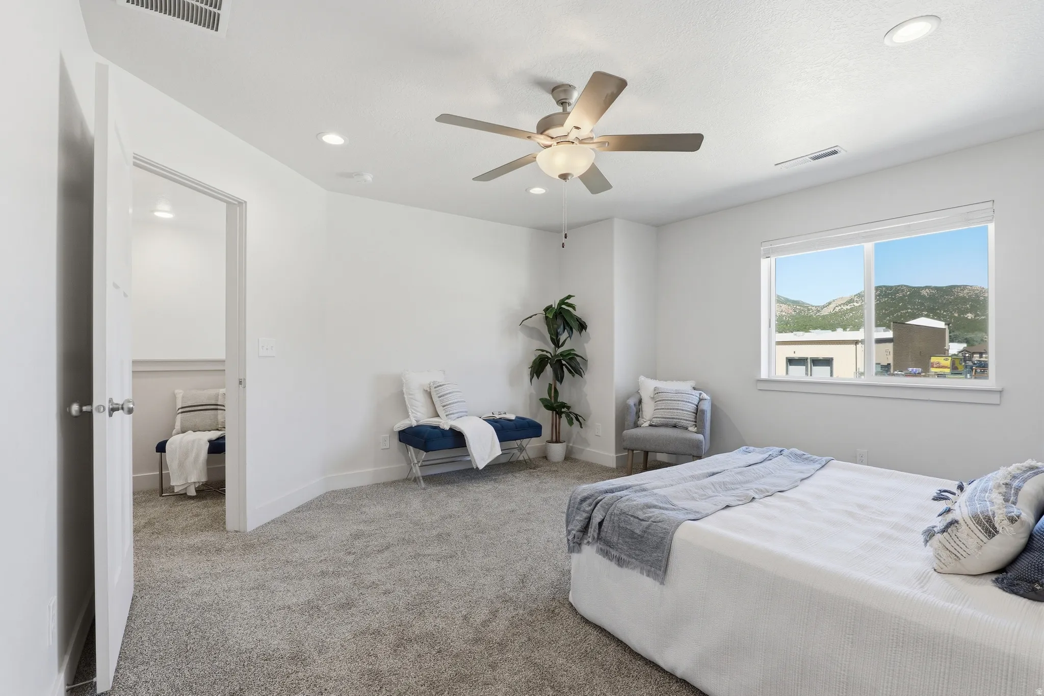 Spacious bedroom featuring light gray carpeting, recessed lighting, and a ceiling fan