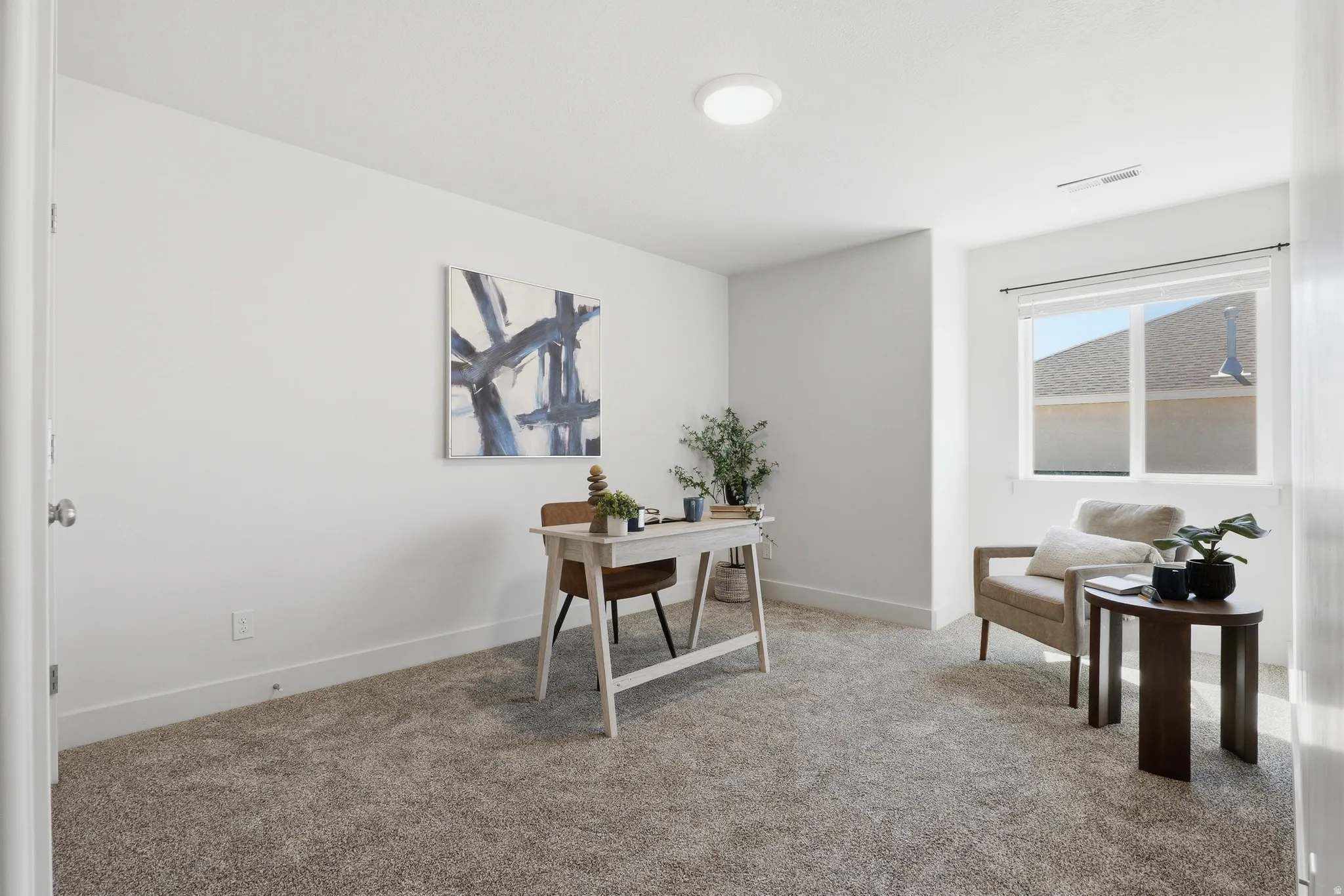 Spacious room featuring neutral carpeting, white walls, a single window, and a flush-mount ceiling light