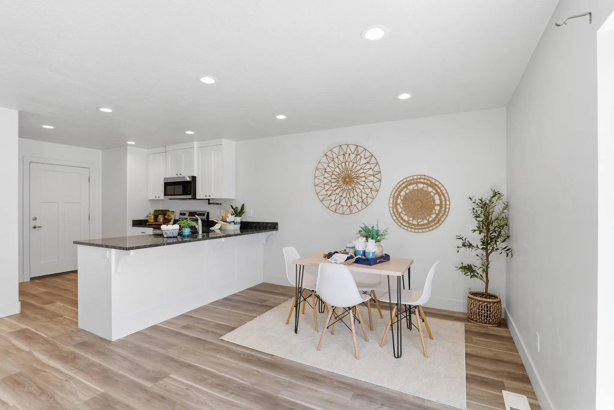 Open-concept dining area featuring wood-finish flooring, white walls, and recessed lighting