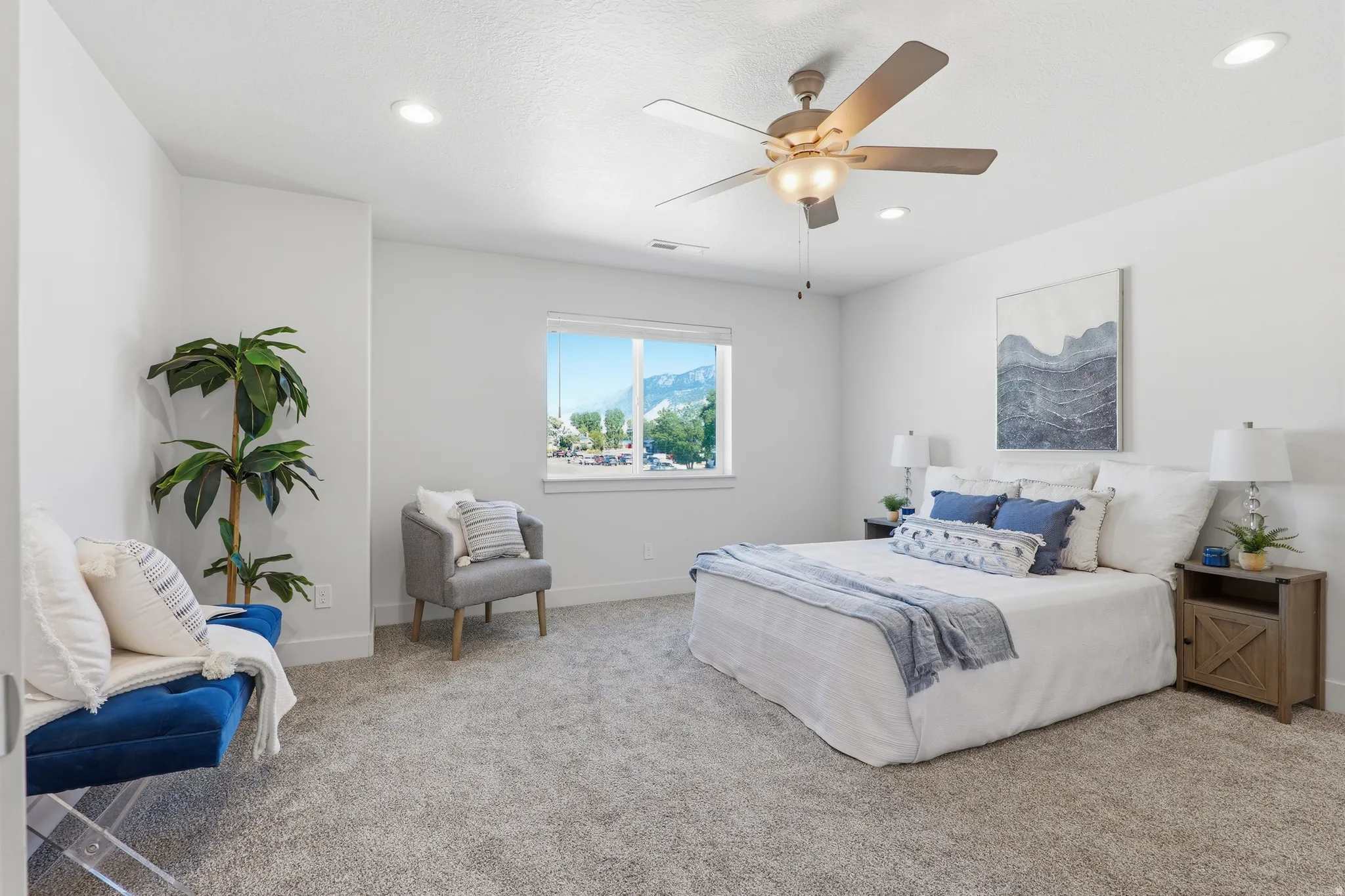 Carpeted room with a ceiling fan, recessed lighting, and a large window offering mountain scenery