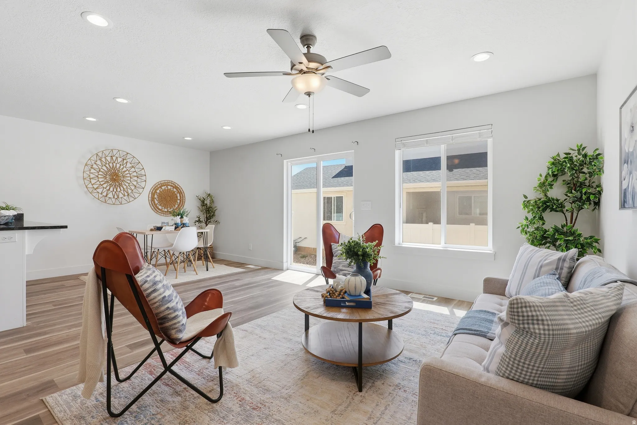 Open-concept living area featuring wood-finish flooring, recessed lighting, and a ceiling fan