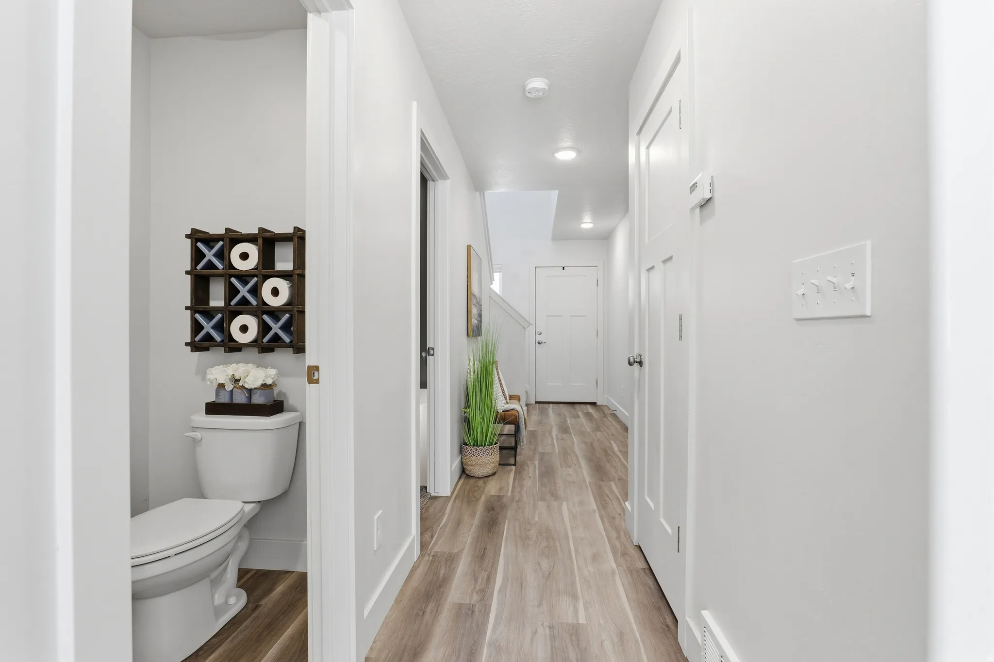 Bright hallway featuring light wood-finish flooring and recessed lighting