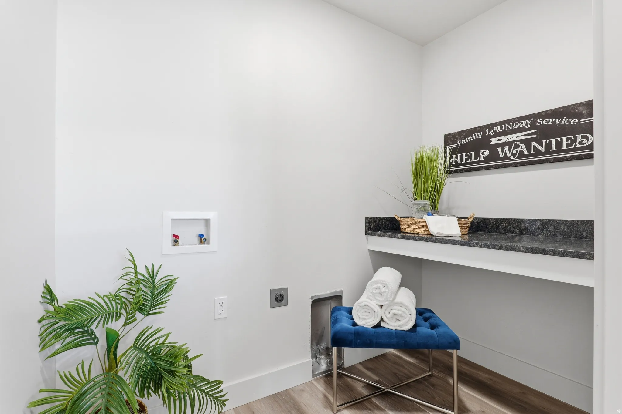 Dedicated laundry area featuring a dark granite-look countertop and white cabinetry