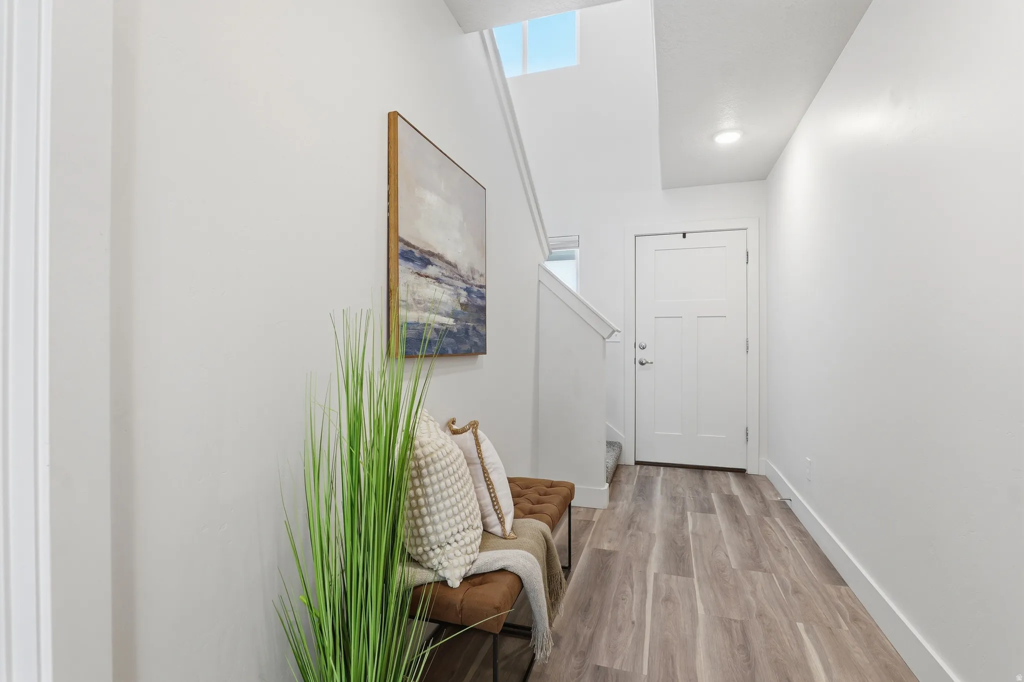 Entryway featuring light wood-finish flooring, white walls, and a white paneled door