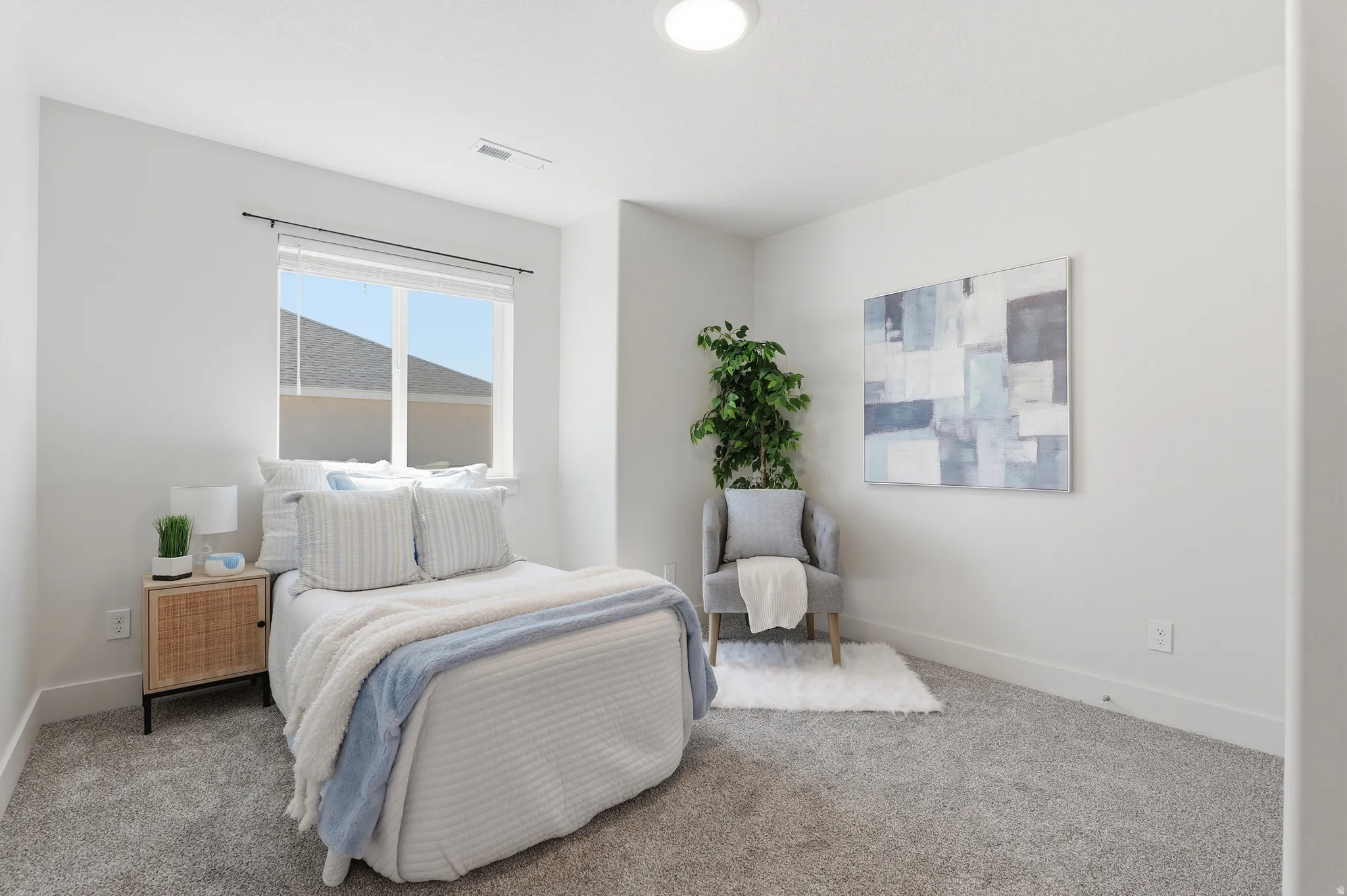 Bright interior room featuring a large window, neutral wall paint, gray carpet, and a flush-mount ceiling light