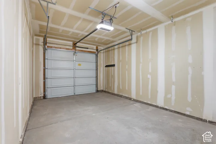Spacious garage featuring a concrete floor, overhead lighting fixture, and a sectional garage door