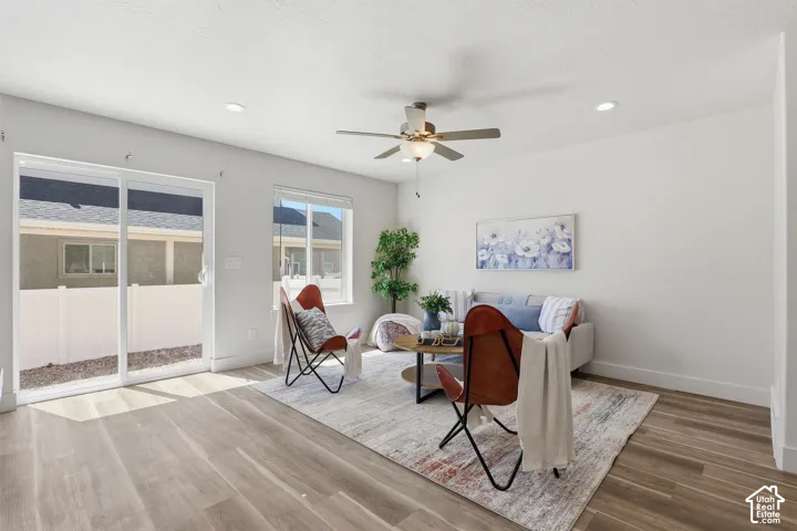 Bright living space featuring wood-finish flooring, recessed lighting, and a ceiling fan