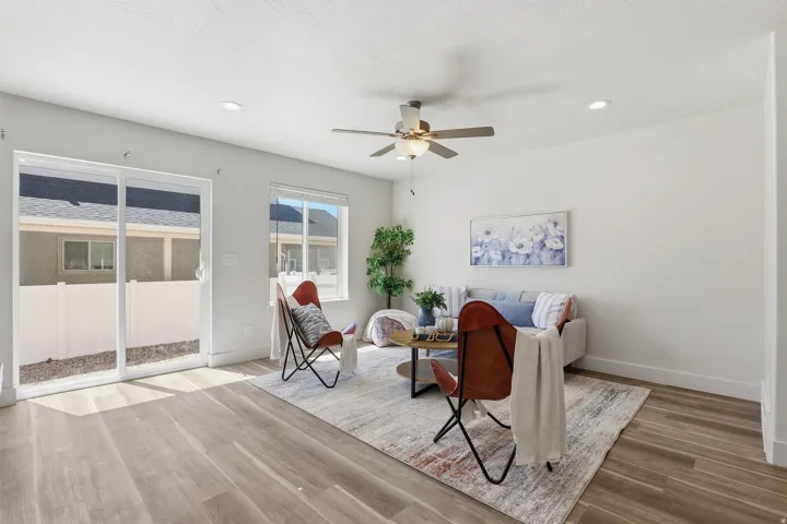 Bright living space featuring wood-finish flooring, recessed lighting, and a ceiling fan