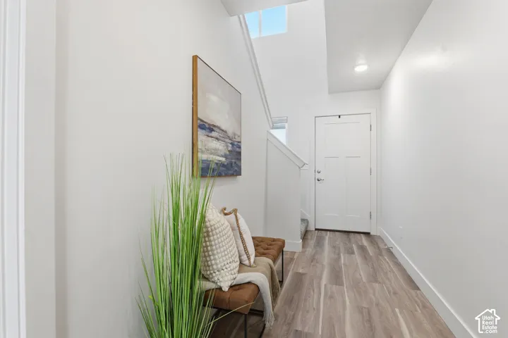 Entryway featuring light wood-finish flooring, white walls, and a white paneled door