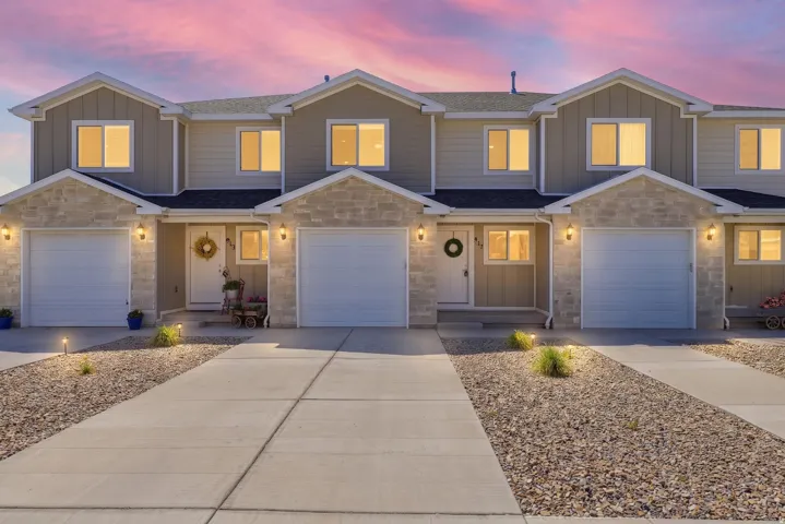 Modern townhome-style residences featuring light-colored siding and stone facade accents
