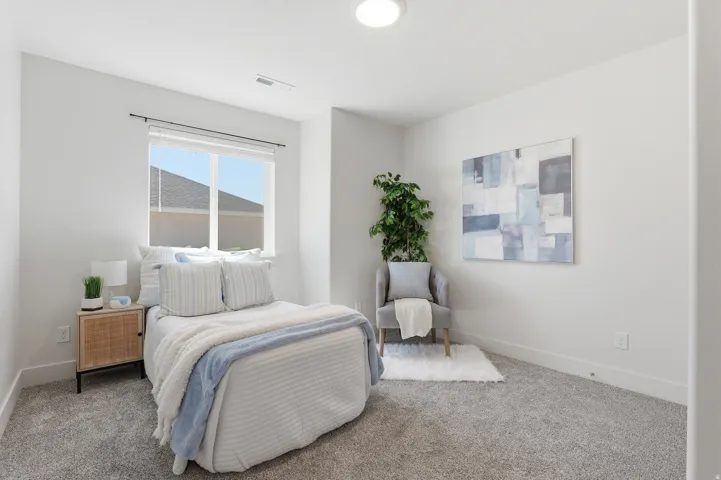 Bright interior room featuring a large window, neutral wall paint, gray carpet, and a flush-mount ceiling light