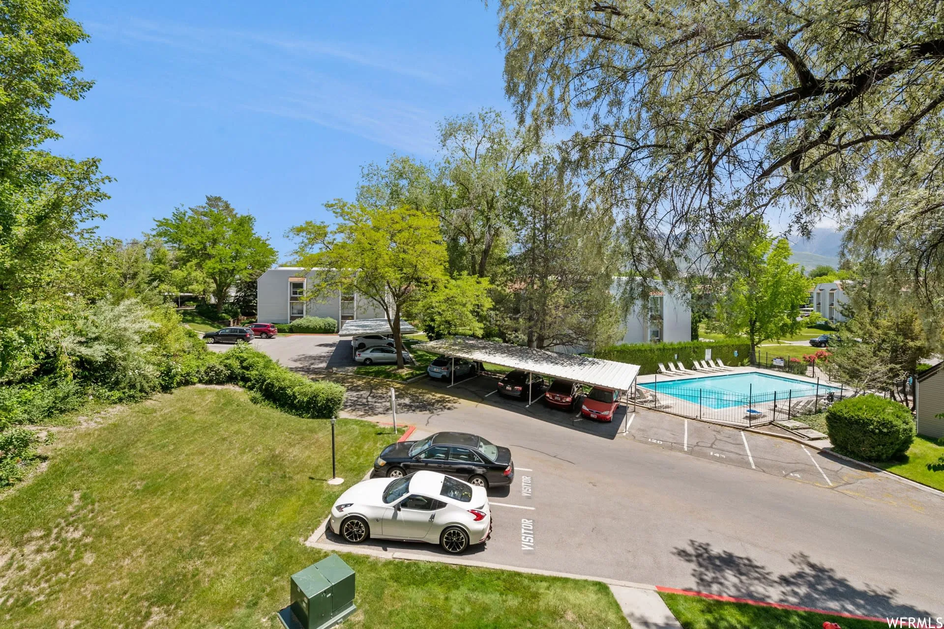 Community amenities featuring a swimming pool, covered parking, and an expansive lawn area