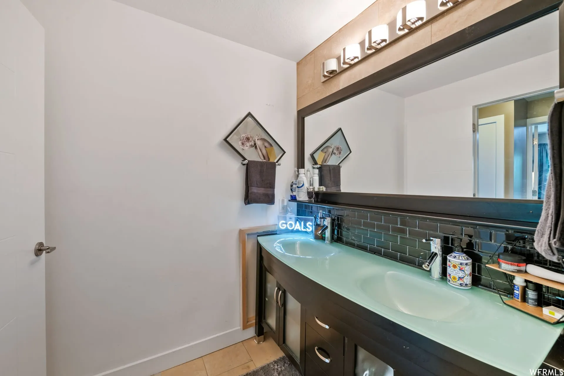 Double vanity with frosted glass countertops and integrated sinks