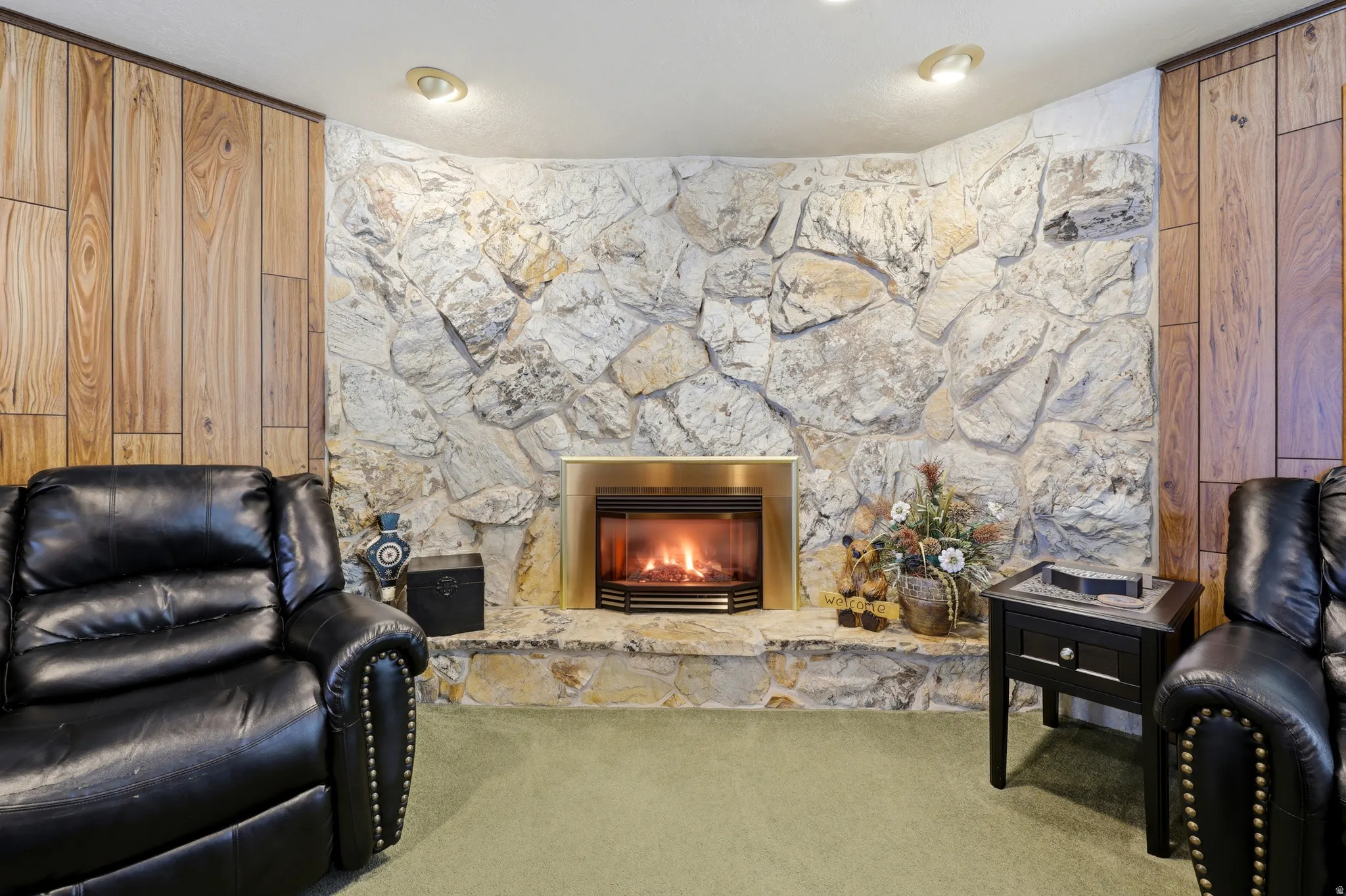 Stone-faced fireplace with a brass-toned insert and hearth