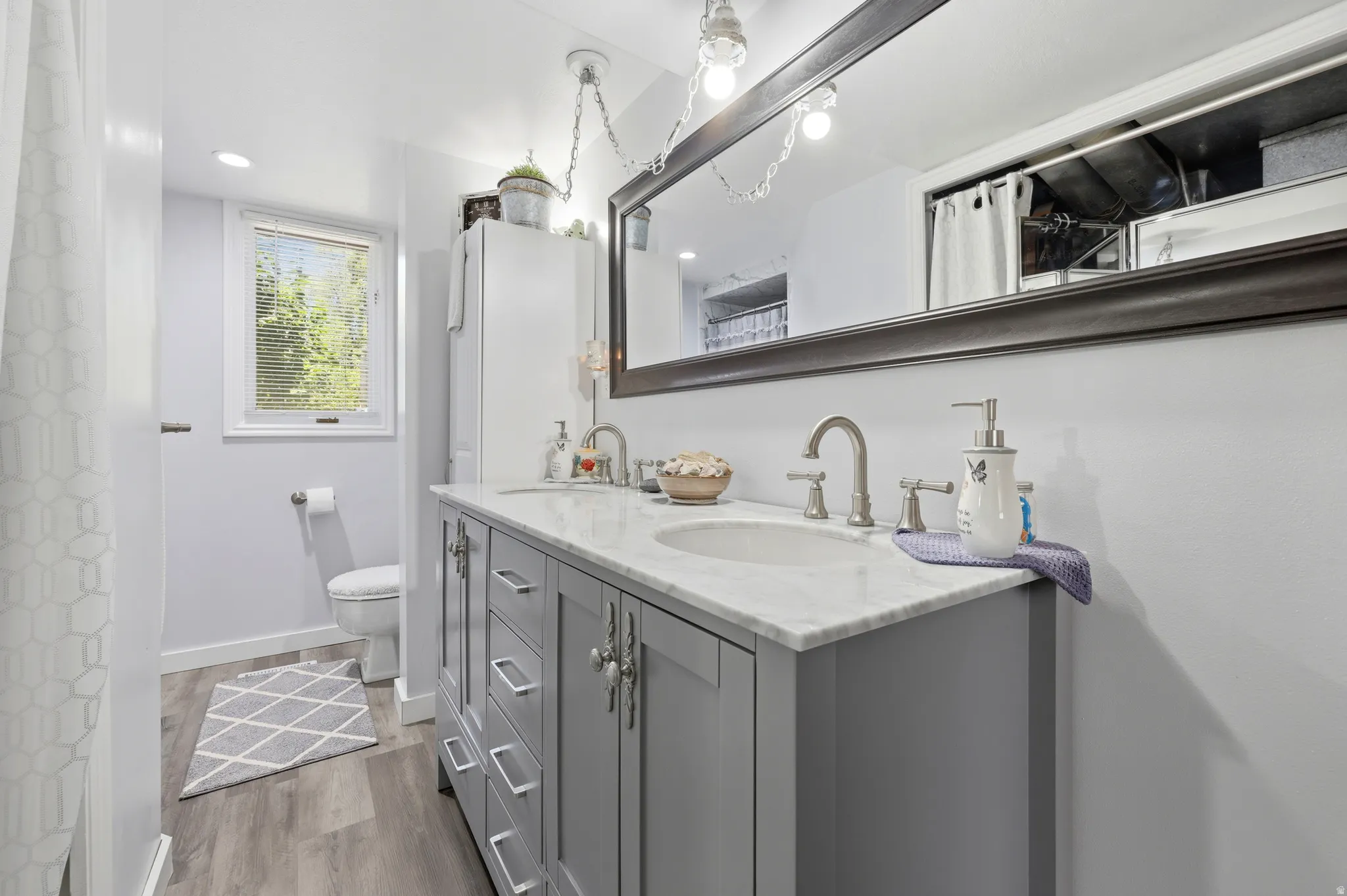 Double vanity featuring a light gray base cabinet, white countertop, and dual undermount sinks with brushed nickel faucets