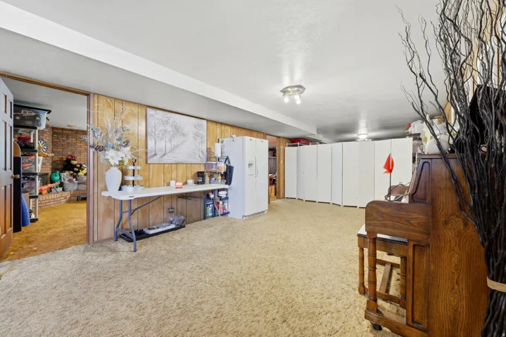 Spacious room featuring wood-panel walls, neutral carpet, recessed lighting, and a white ceiling