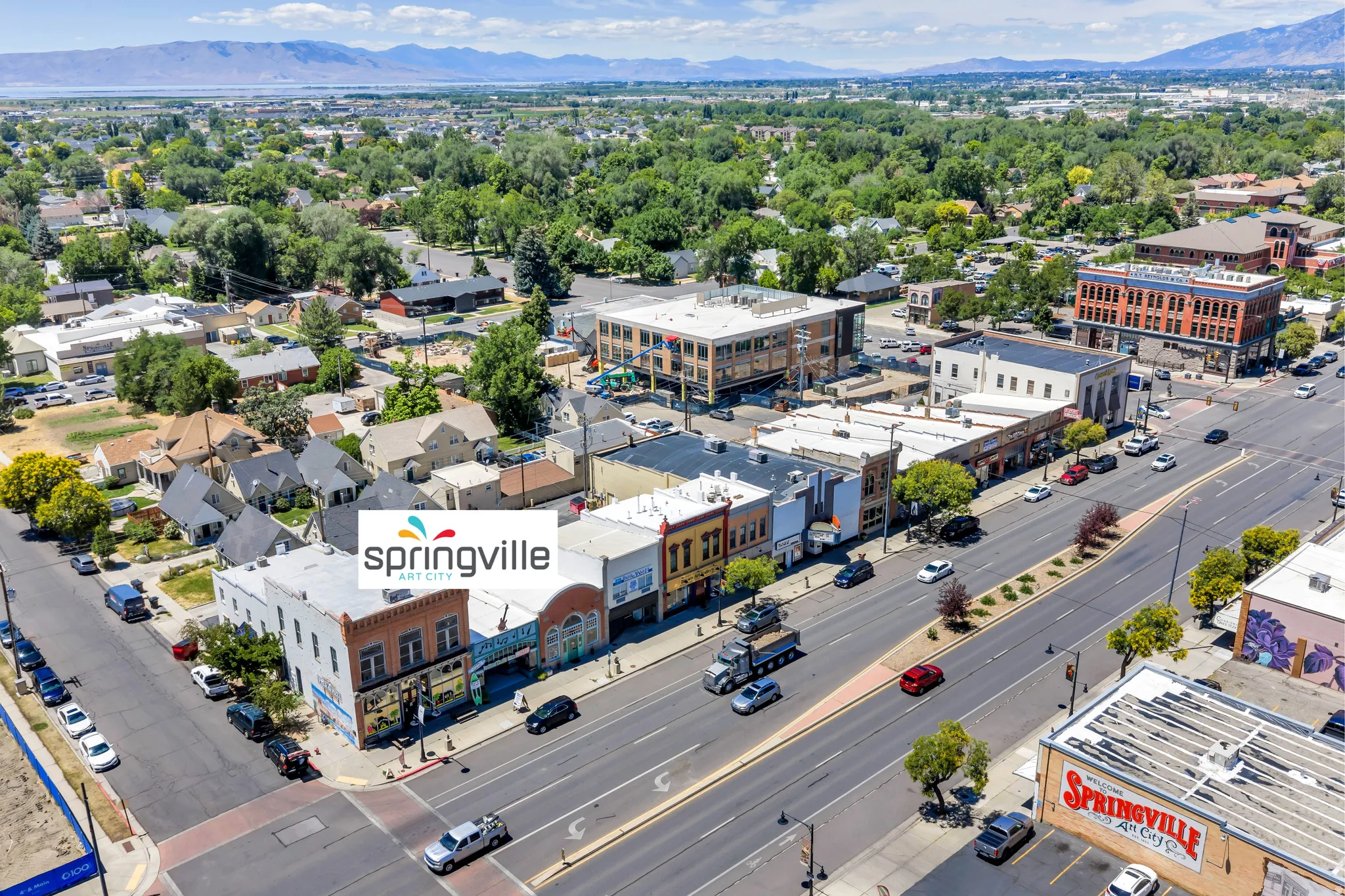 Urban landscape featuring commercial buildings, residential structures, and a prominent multi-lane roadway