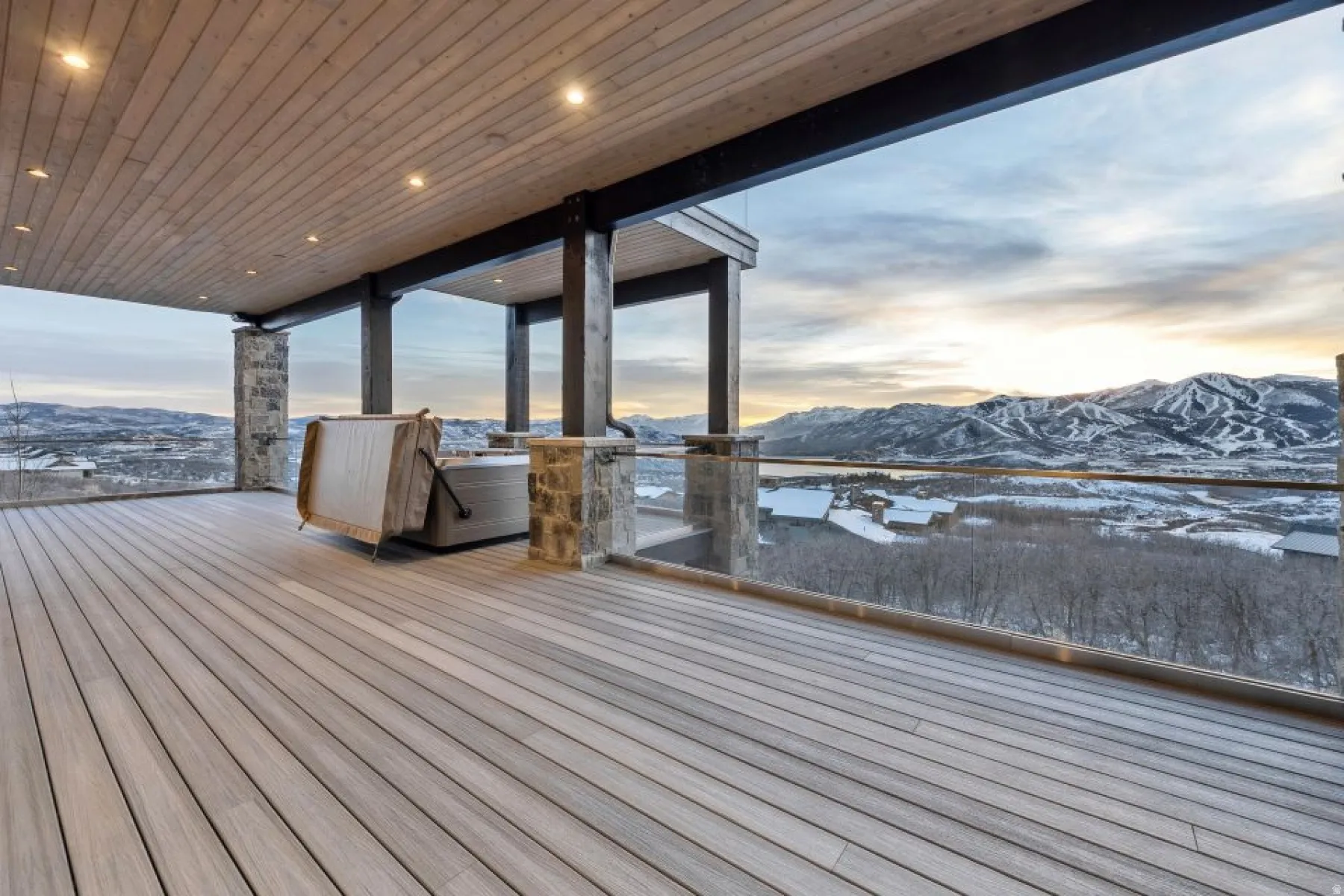 Expansive outdoor deck featuring wood-finish flooring and a hot tub