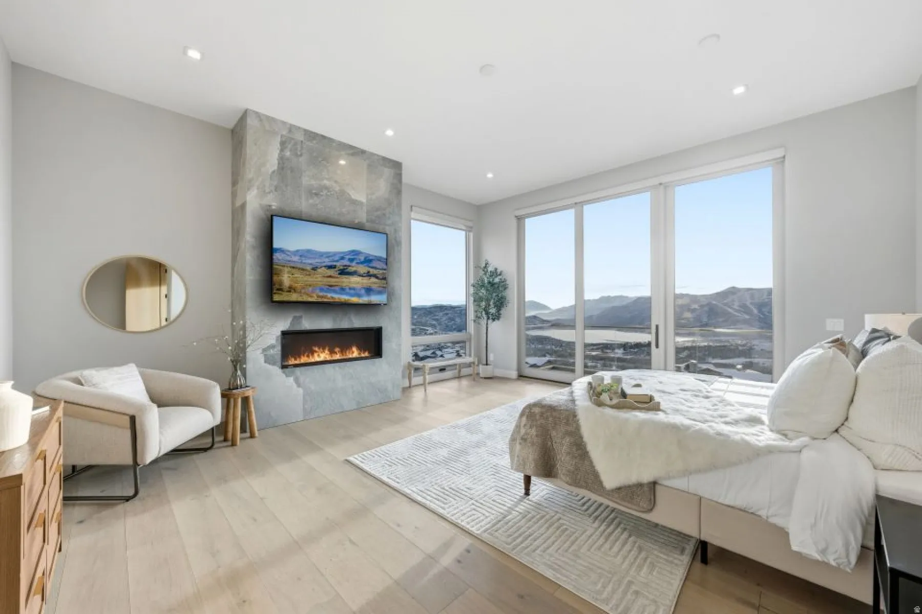 Spacious room featuring wood-finish flooring and a stone-clad fireplace with an integrated linear firebox