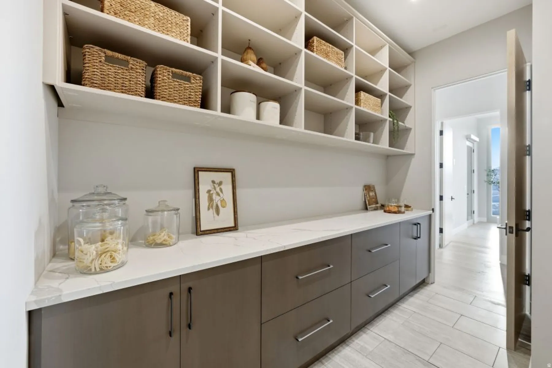 Expansive pantry featuring extensive built-in shelving, a quartz countertop, and integrated base cabinetry