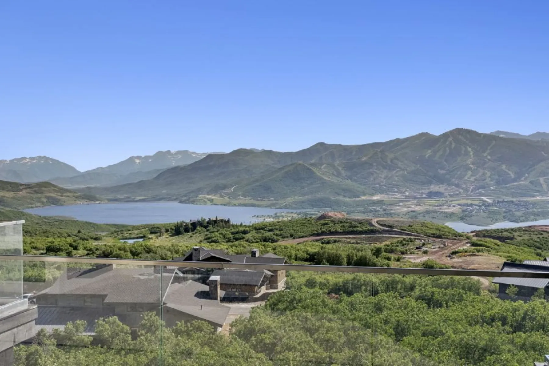 Expansive mountain and lake scenery from a glass-paneled balcony
