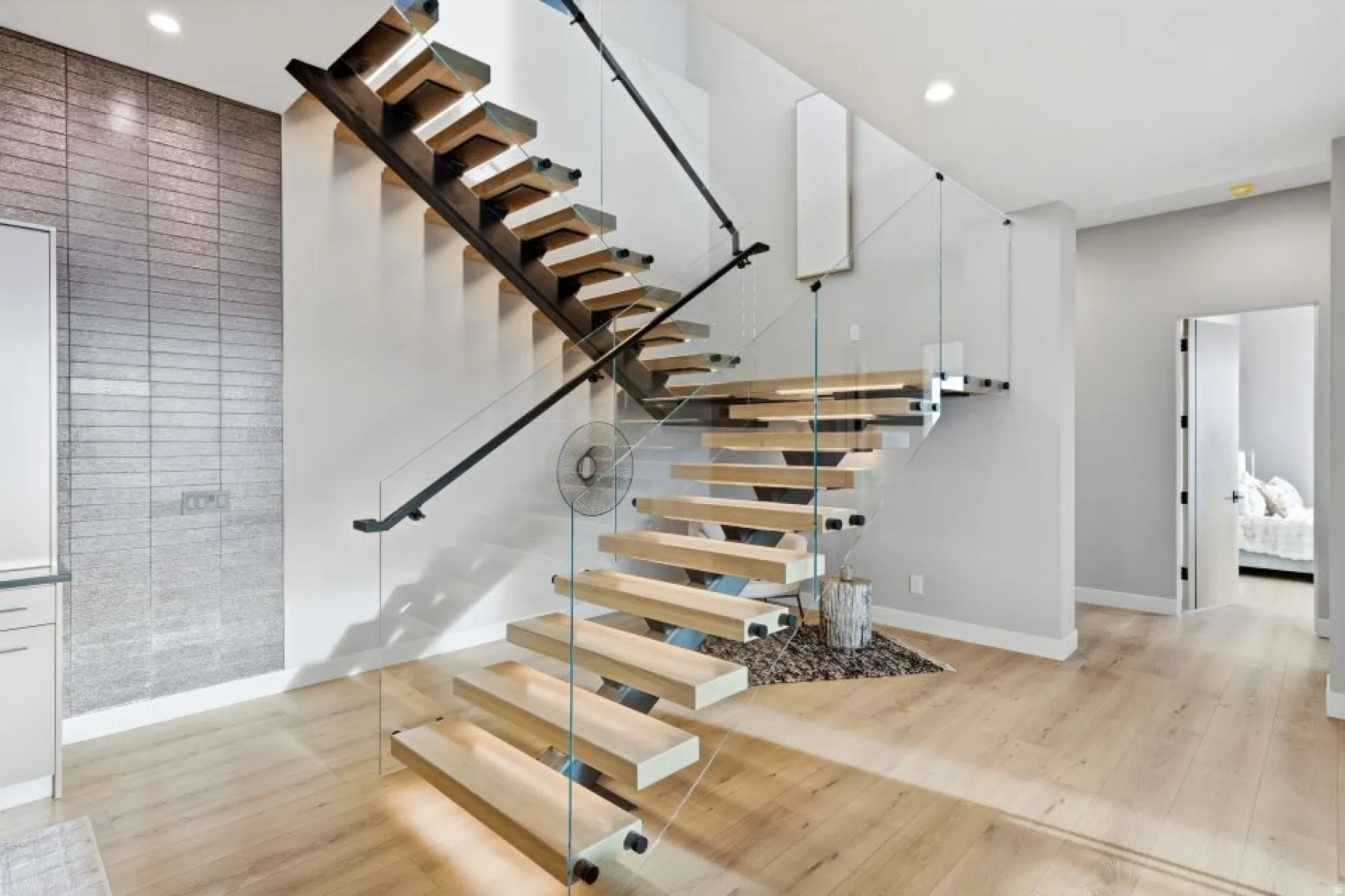 Modern floating staircase featuring natural wood treads and glass railings