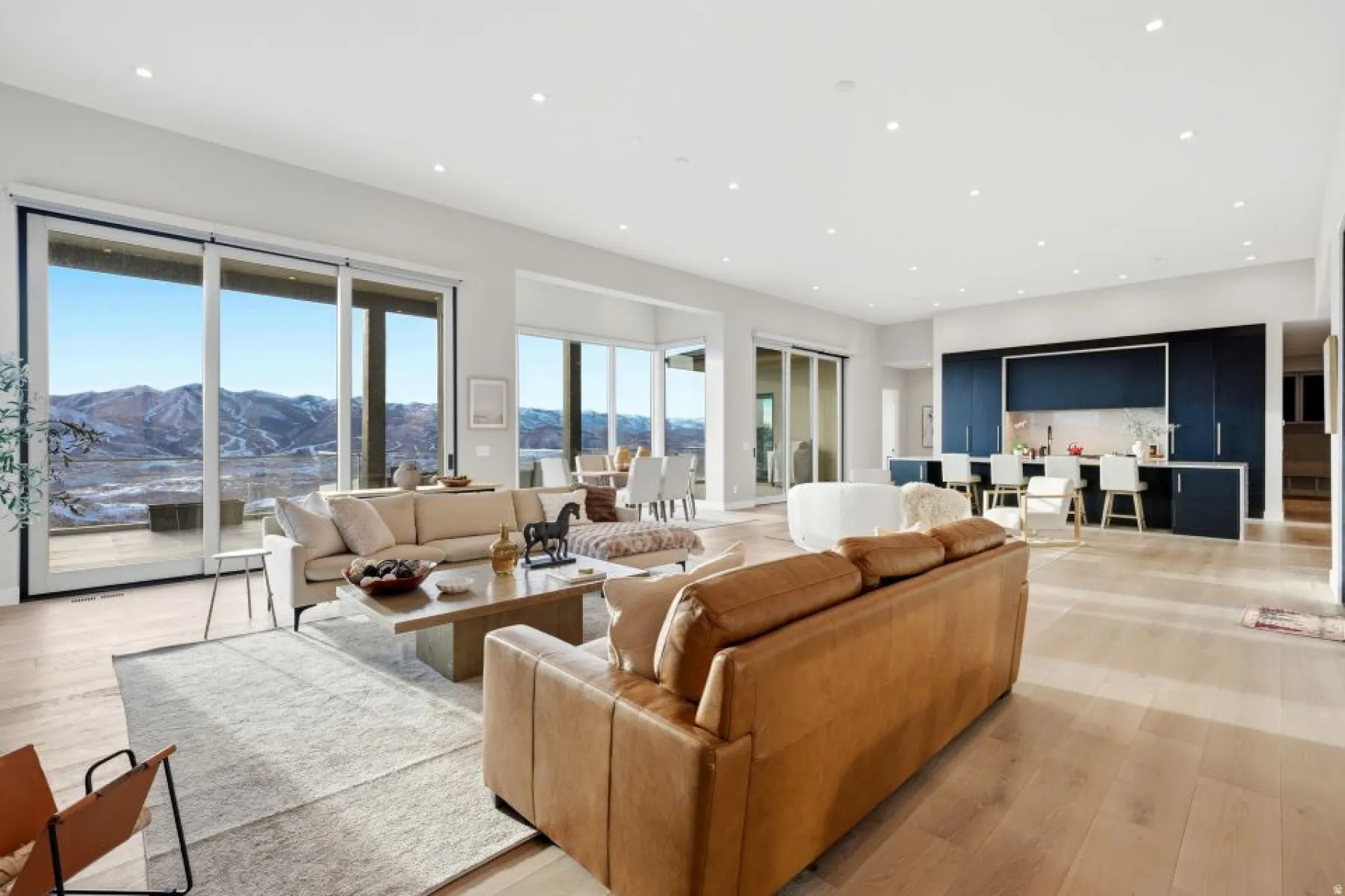 Spacious open-concept living area featuring light wood-finish flooring and recessed lighting