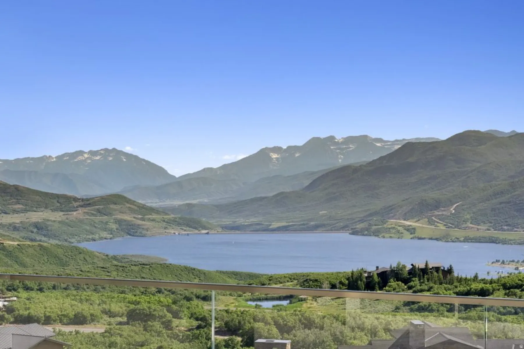 Expansive mountain and lake scenery from a glass-paneled balcony