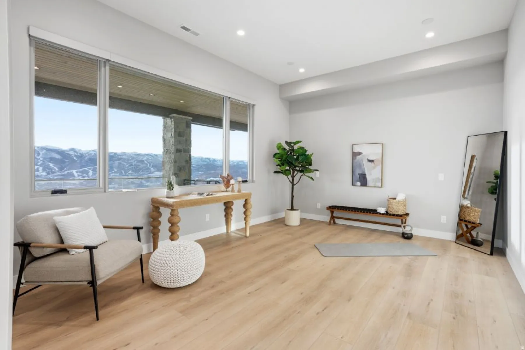 Spacious room featuring floor-to-ceiling windows, wood-finish flooring, recessed lighting, and crisp white baseboards