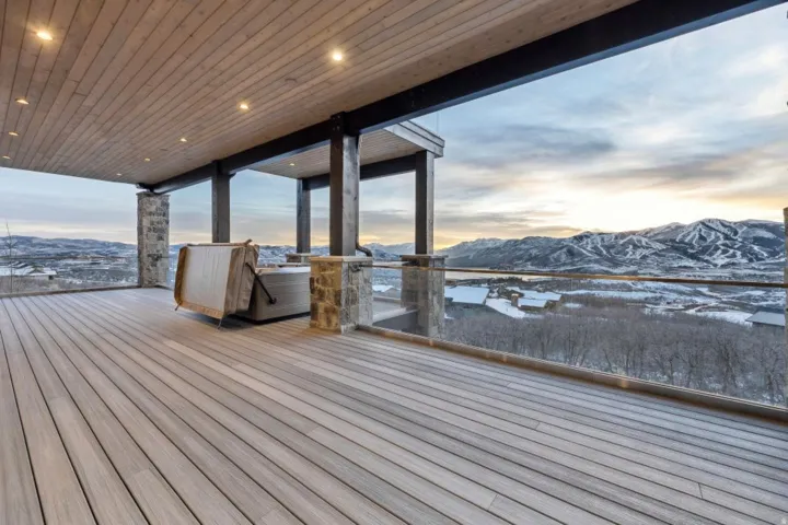 Expansive outdoor deck featuring wood-finish flooring and a hot tub