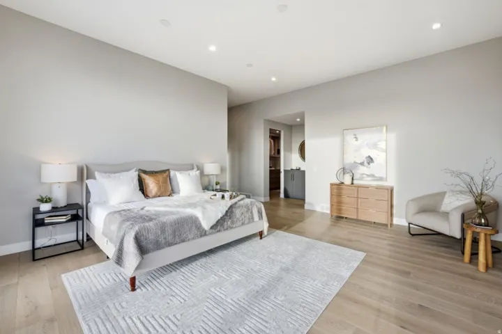 Light wood-finish flooring provides a bright foundation in this spacious room